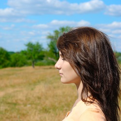 woman in field with eyes closed